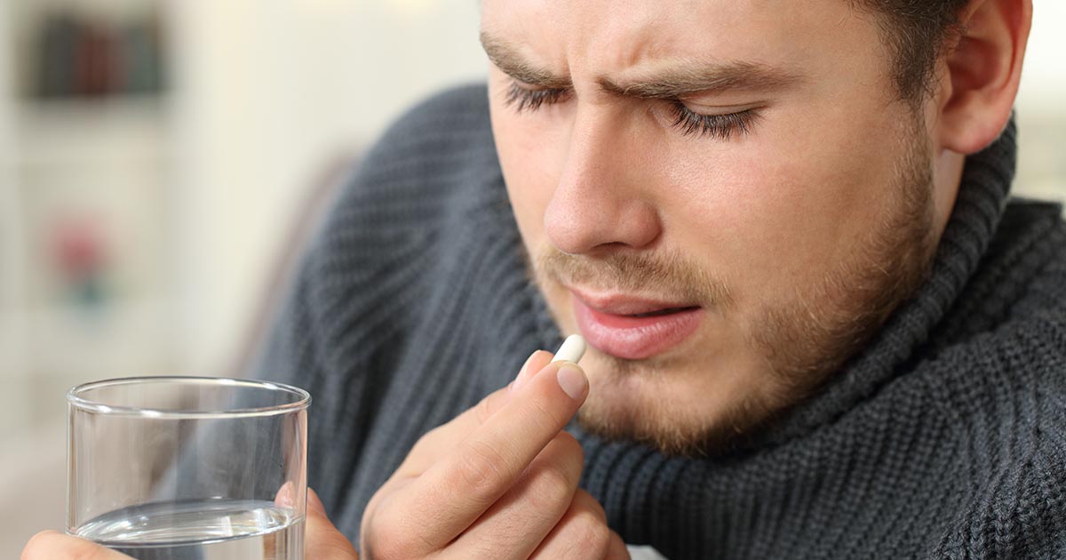 man-swallow-pill-water-AdobeStock